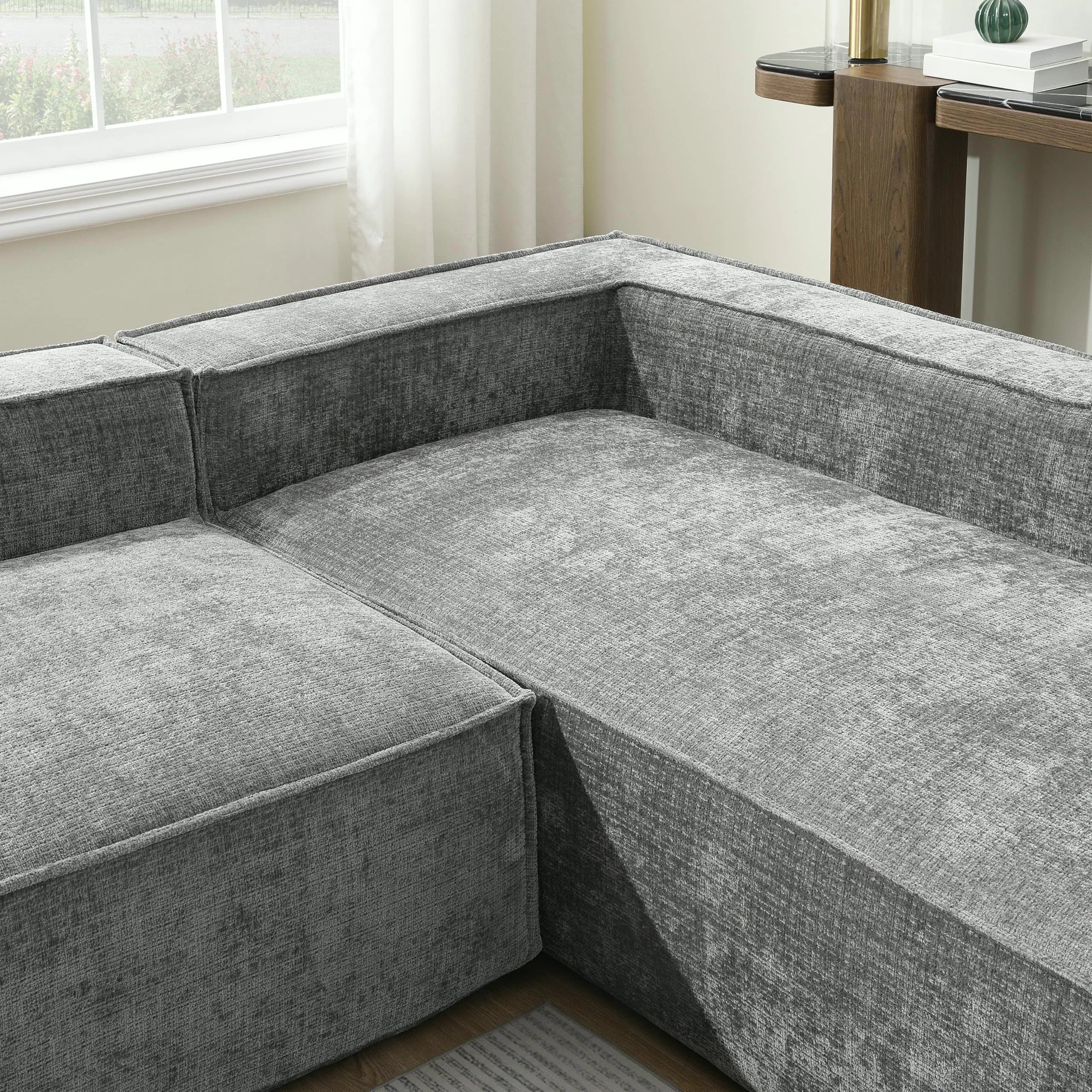 Gray chenille modular sectional pieces pushed together into a corner